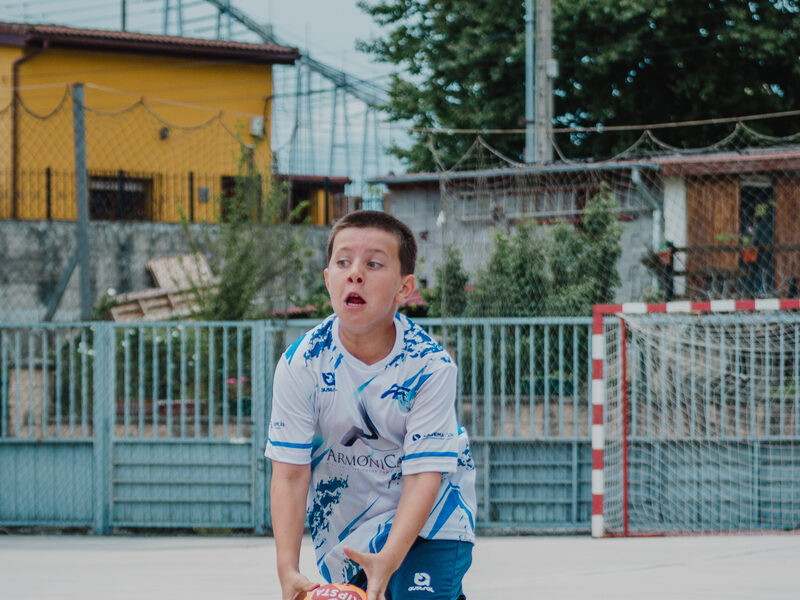 Joven botando el balon en la pista exterior